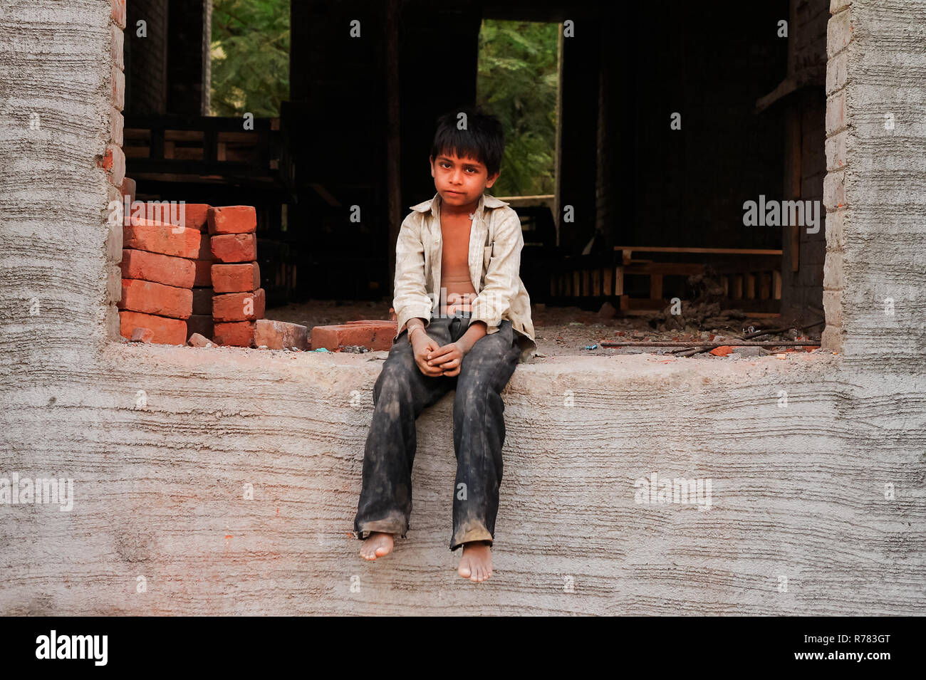 New Delhi, Indien - 20. Oktober 2017: Porträt der Jungen arbeiten als Maurer in Konstruktion mit schmutzigen Kleidung und trauriges Gesicht mit resignatio Stockfoto