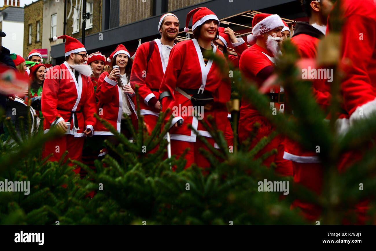 Teilnehmer gekleidet in Santa Kostüme den Weg durch die Straßen von London, wie sie in London 2018 Santacon nehmen. Stockfoto