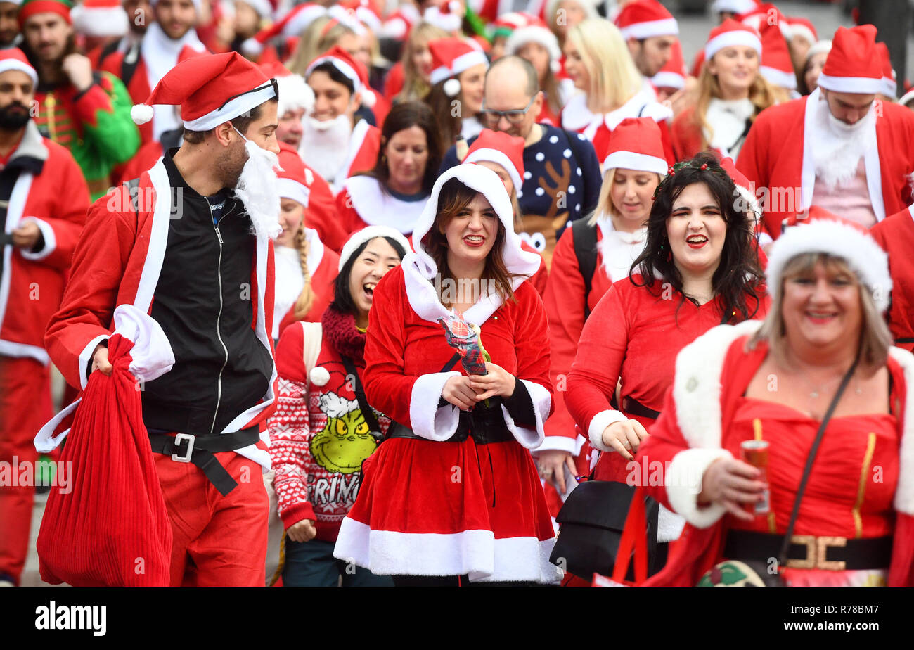 Teilnehmer gekleidet in Santa Kostüme den Weg durch die Straßen von London, wie sie in London 2018 Santacon nehmen. Stockfoto