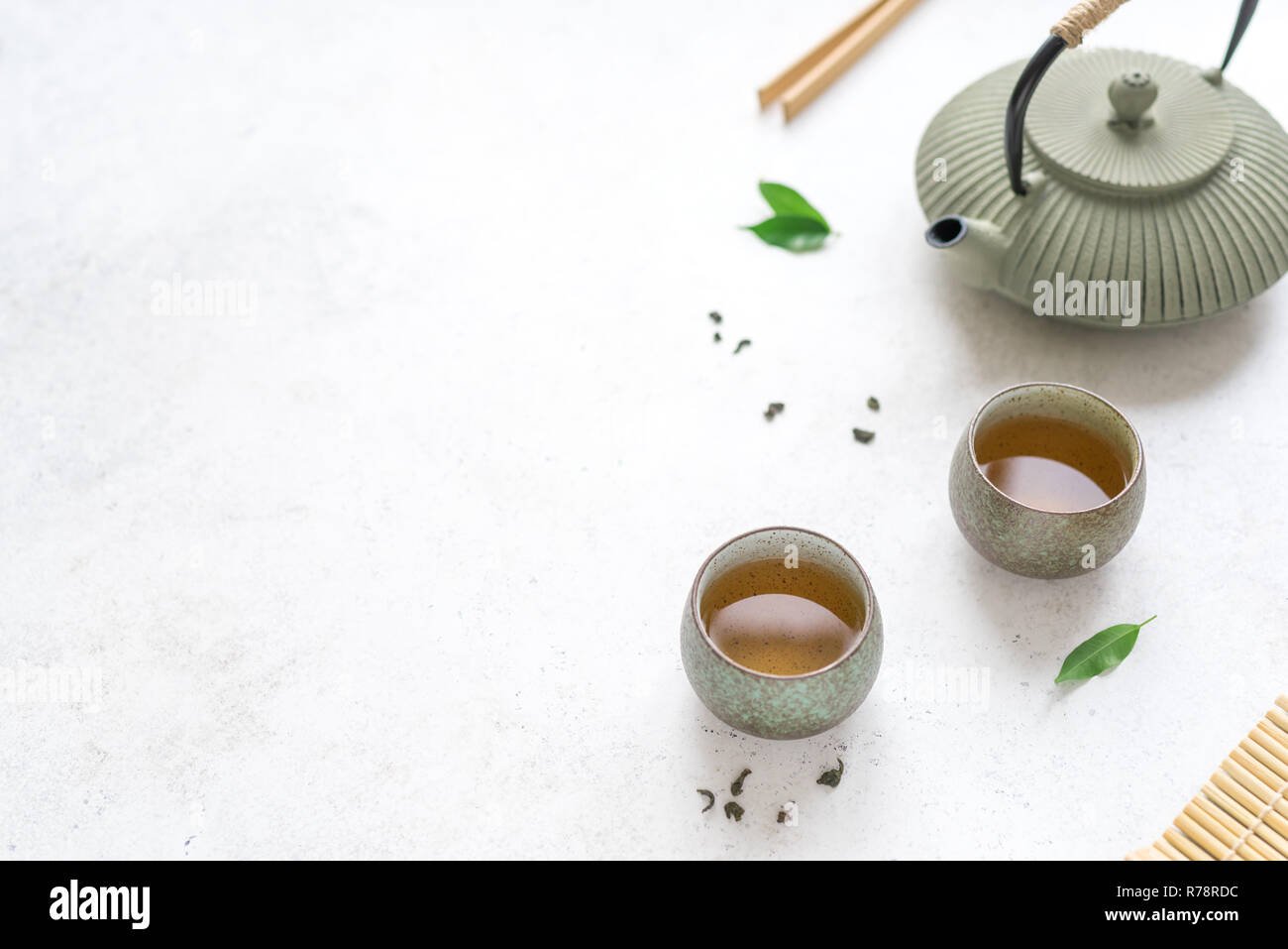 Chinesischer Tee Set Keramik Teekanne und Teetassen mit grünem Tee und Blätter. Traditionelle tee Zusammensetzung auf weißem Hintergrund, kopieren. Stockfoto