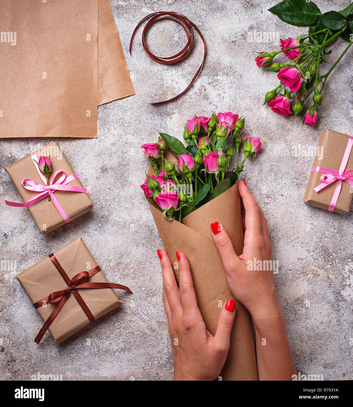 Frauen Hände wickeln Sie einen Blumenstrauß aus Rosen in Papier  Stockfotografie - Alamy