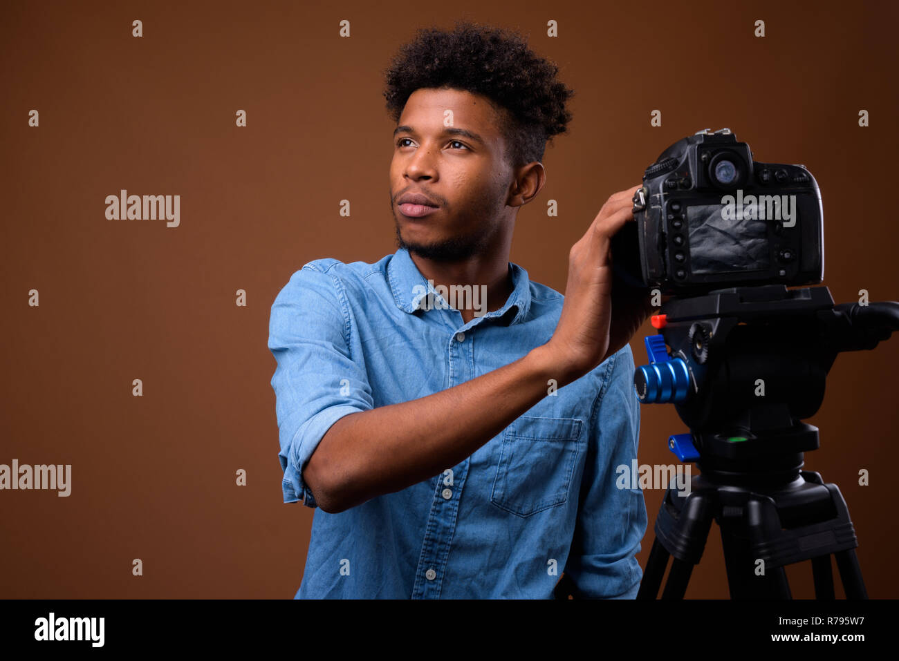 Junge schöne afrikanischer Mann vlogging mit DSLR-Kamera im Studio Stockfoto