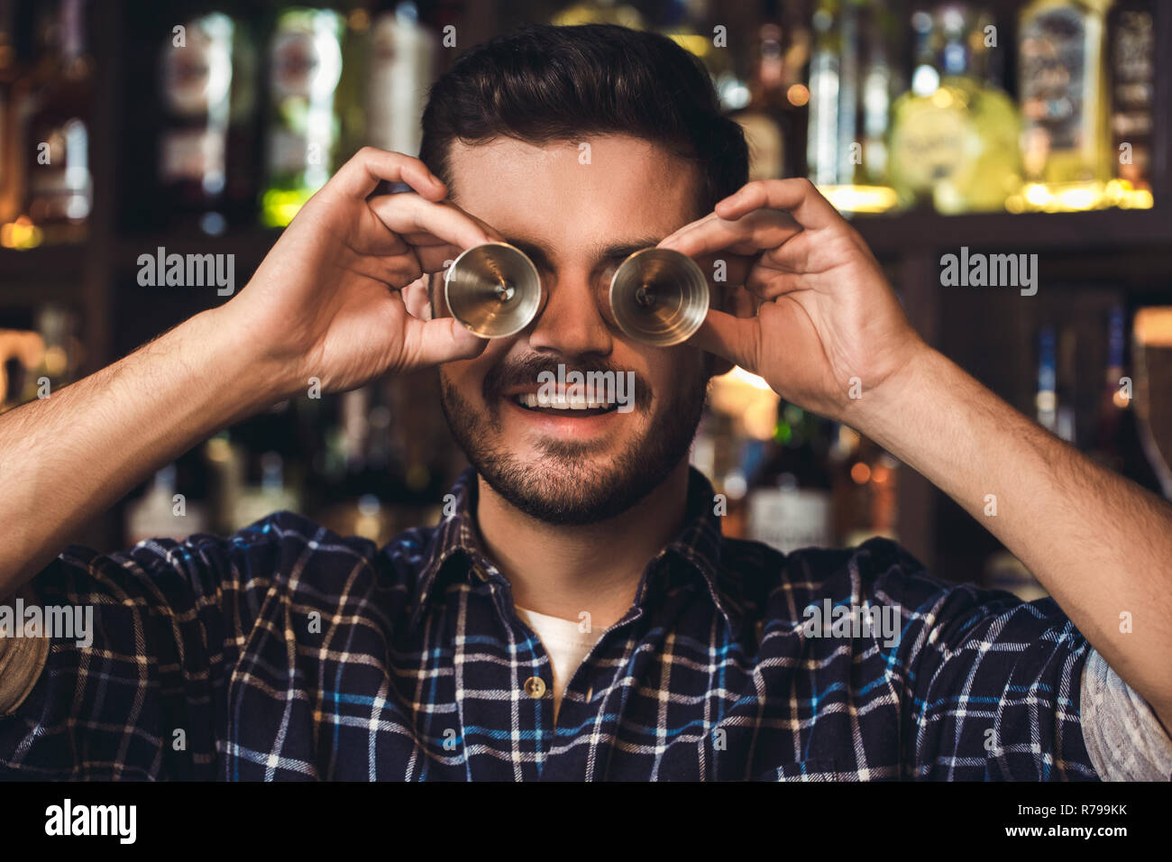 Junge Barkeeper stehen an der Theke, die Augen mit jigger Fröhliche close-up Stockfoto