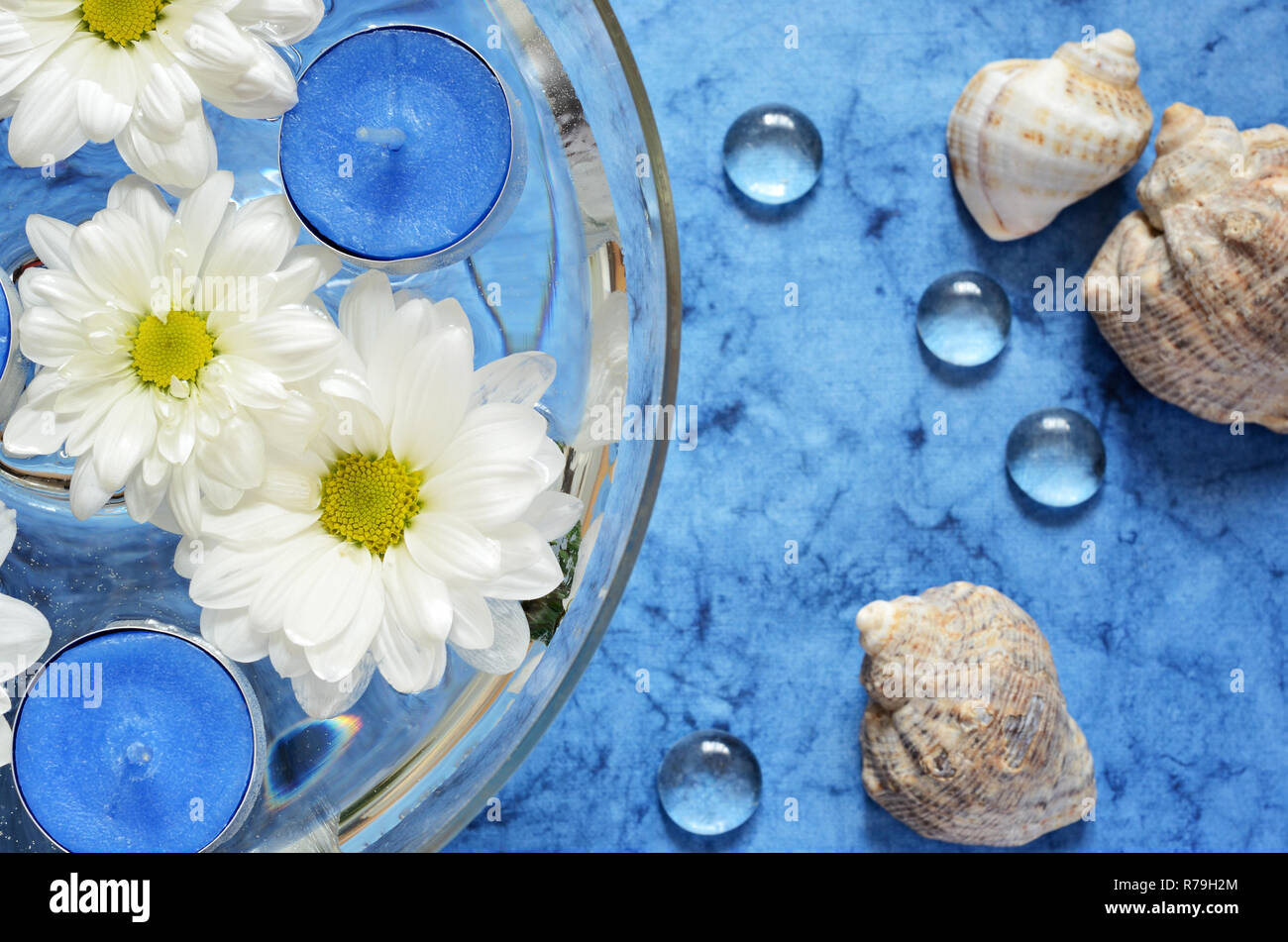 Gänseblümchen und blauen Kerzen im Wasser über dem Meer Hintergrund Stockfoto