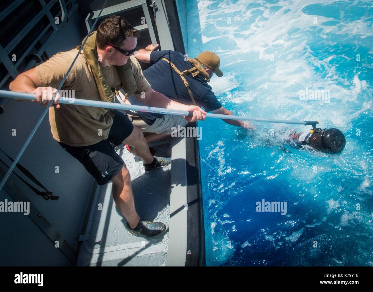 Segler für die Beseitigung von Explosivstoffen Mobile Unit 5 (EODMU 5) Platoon 142 zugeordnet Erholen ein unbemanntes Unterwasserfahrzeug auf eine Küste Riverine Gruppe 1 Loslösung Guam MK VI Patrouillenboot in den Pazifischen Ozean 10. Mai 2017. EODMU 5 prüft derzeit die Möglichkeit, Vermögenswerte aus verschiedenen Plattformen, einschließlich Hubschrauber- und Patrouillenboote, die adaptive Interoperabilität zu erhöhen. 5 EODMU führt meine Gegenmaßnahmen, Improvised Explosive Device operations, macht sicher explosive Gefahren und entwaffnet Unterwasser sprengstoffe wie Minen. Stockfoto