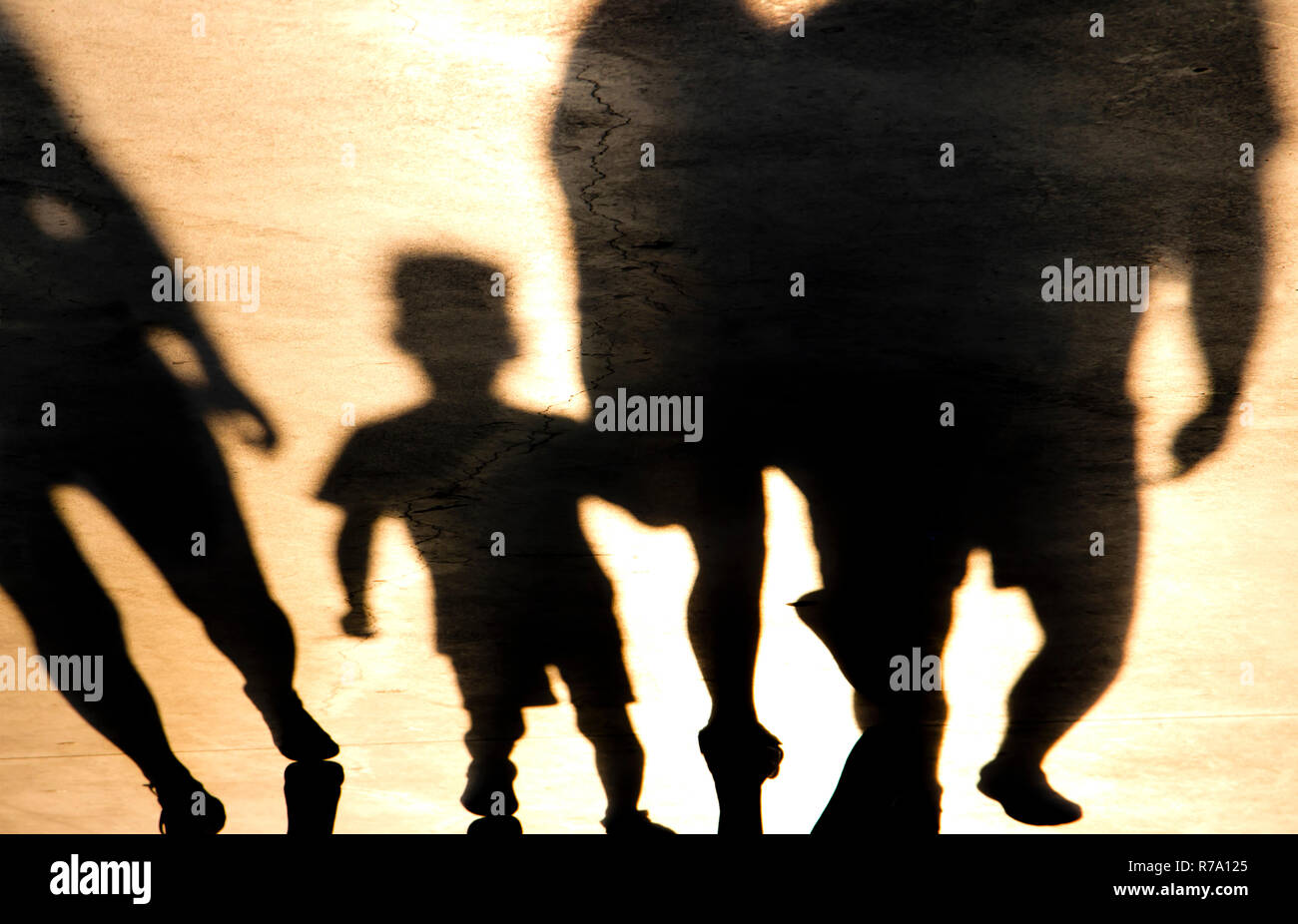 Verschwommene Schatten eines Jungen und erwachsene Walking im Sonnenuntergang Stockfoto