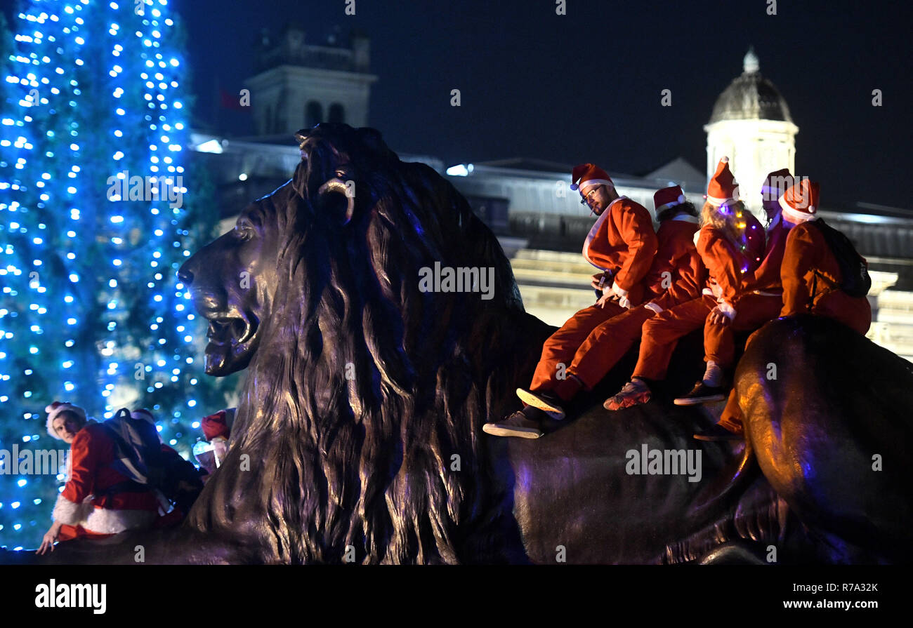 Menschen in Santa Kostüme auf dem Trafalgar Square, London, als sie an Santacon London 2018. Stockfoto