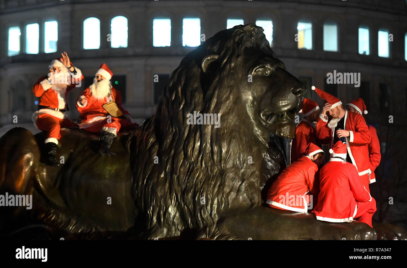 Menschen in Santa Kostüme auf dem Trafalgar Square, London, als sie an Santacon London 2018. Stockfoto