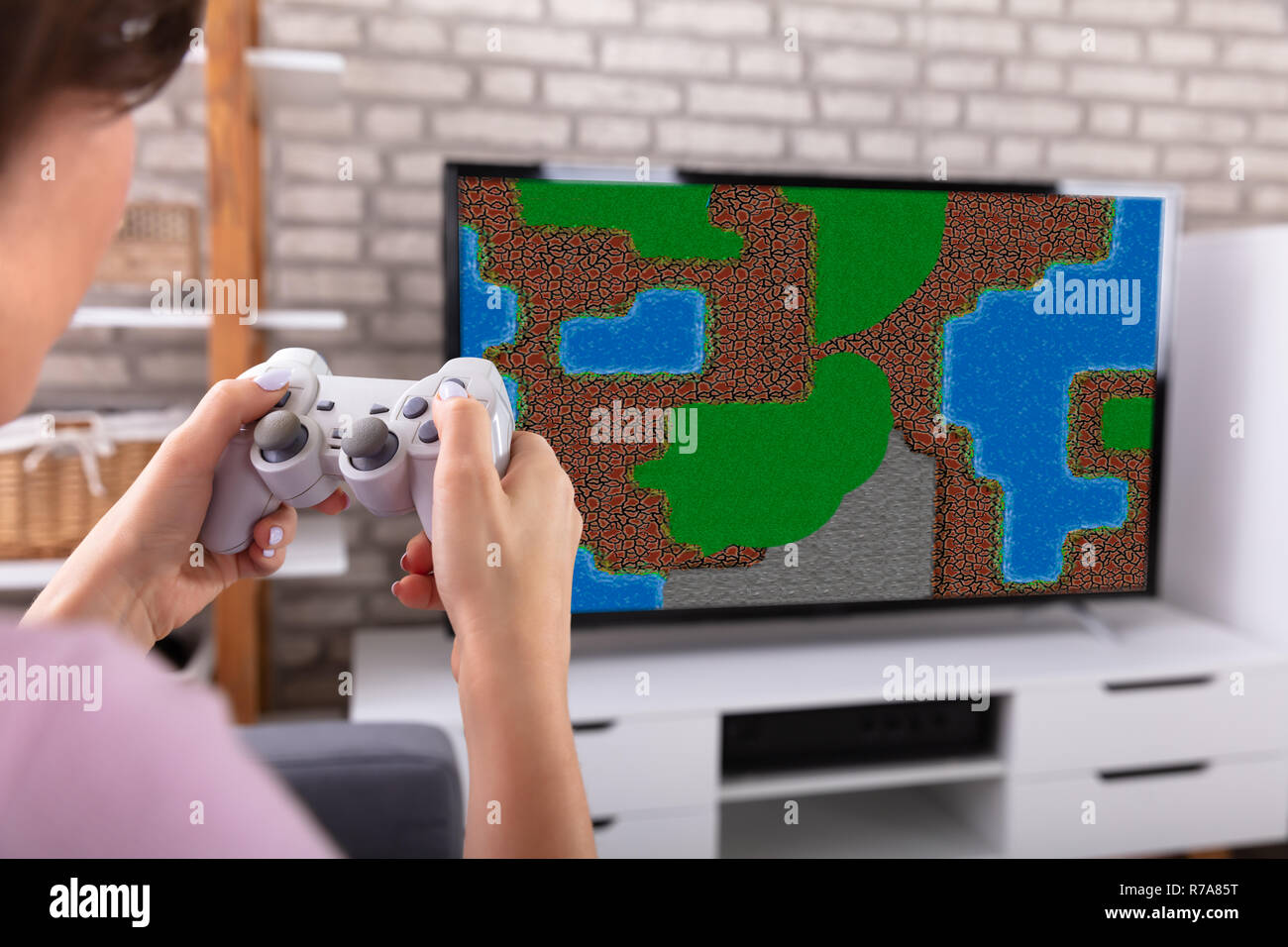 Frau mit Joystick beim Spielen von Spiel zu Hause im Fernsehen Stockfoto