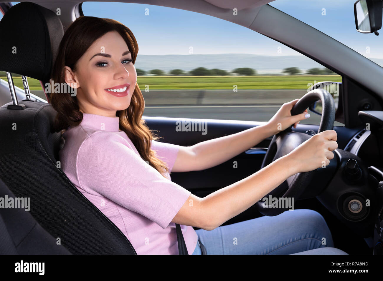 Seitenansicht einer jungen Frau, die mit dem Auto anreisen, Stockfoto