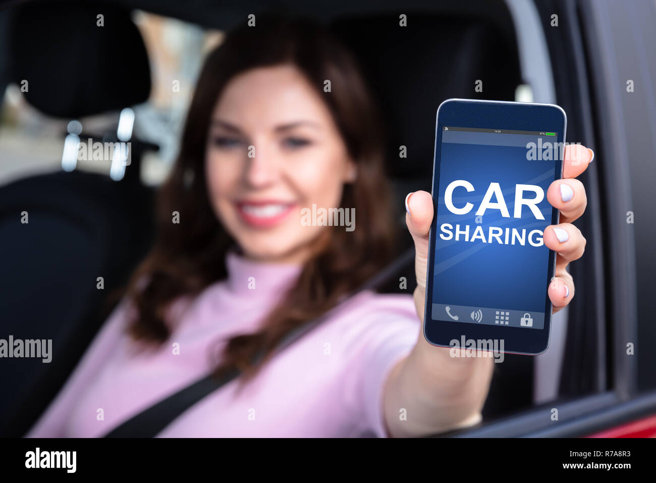 Nahaufnahme von einer Frau Hand Sitzen im Auto, Car Sharing App auf dem Smartphone Stockfoto