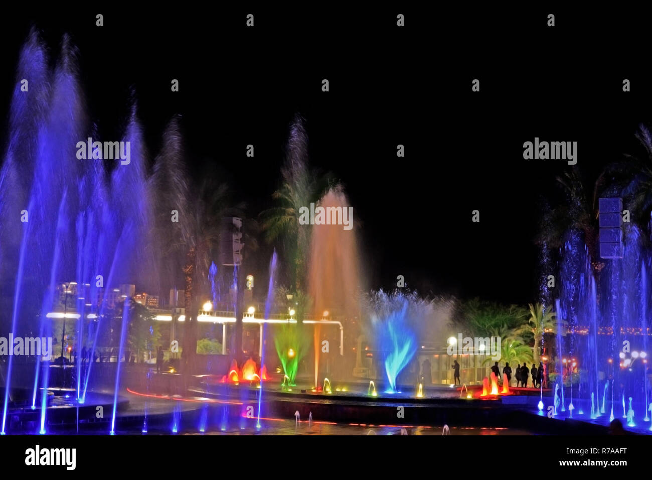 Eine glühende Musikalischen Fontäne bei Nacht. Spritzer von gefärbtes Wasser. Stockfoto