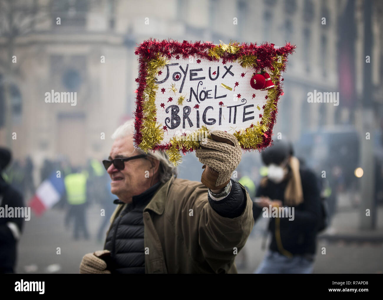 Paris, Frankreich. 8 Dez, 2018. Ein alter Mann gesehen, die ein Schild mit der Aufschrift "Merry Chrismas Brigitte" in der Nähe des Arc de Triomphe während der Protest gelbe Weste' in Paris. Ohne politische Zugehörigkeit, Bewegung Kundgebungen der''˜ gelbe Weste' in verschiedenen Städten in Frankreich in diesem Samstag gegen Steuern und steigende Kraftstoffpreise. Credit: Sathiri Kelapa/SOPA Images/ZUMA Draht/Alamy leben Nachrichten Stockfoto