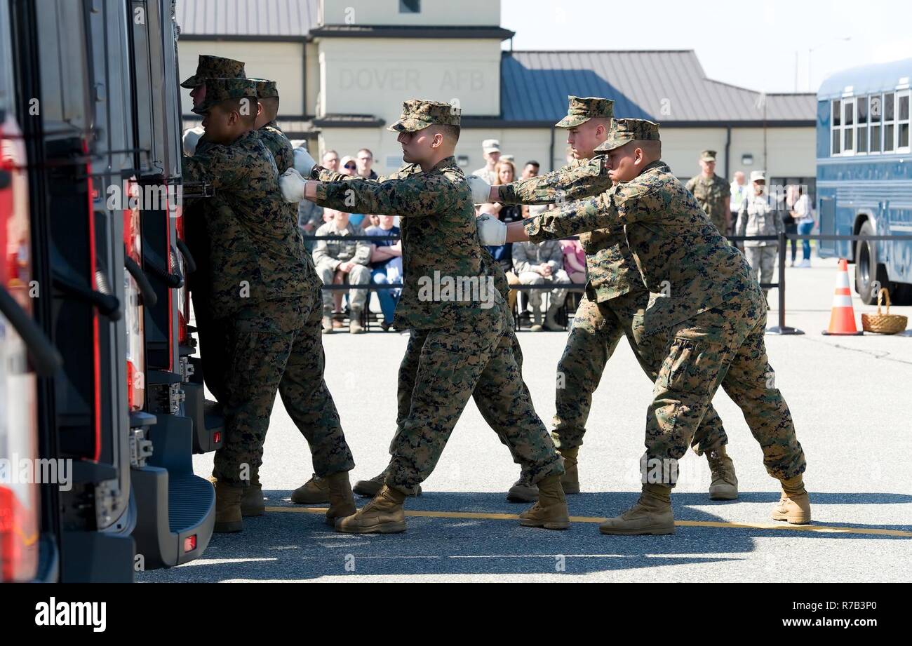 Ein U.S. Marine Corps tragen Team steht nach dem Verteilergetriebe in der Leichenhalle transfer Fahrzeug während eines simulierten würdige Übertragung April 11, 2017, auf Dover Air Force Base, Del im Hintergrund, Personen, die die Rolle der Familienmitglieder an die würdige Übertragung gespielt, passte die Marines die simulierte Gefallen service Mitglied aus der C-17 Globemaster III, vorbei an der offiziellen Partei und in den MTV. Stockfoto