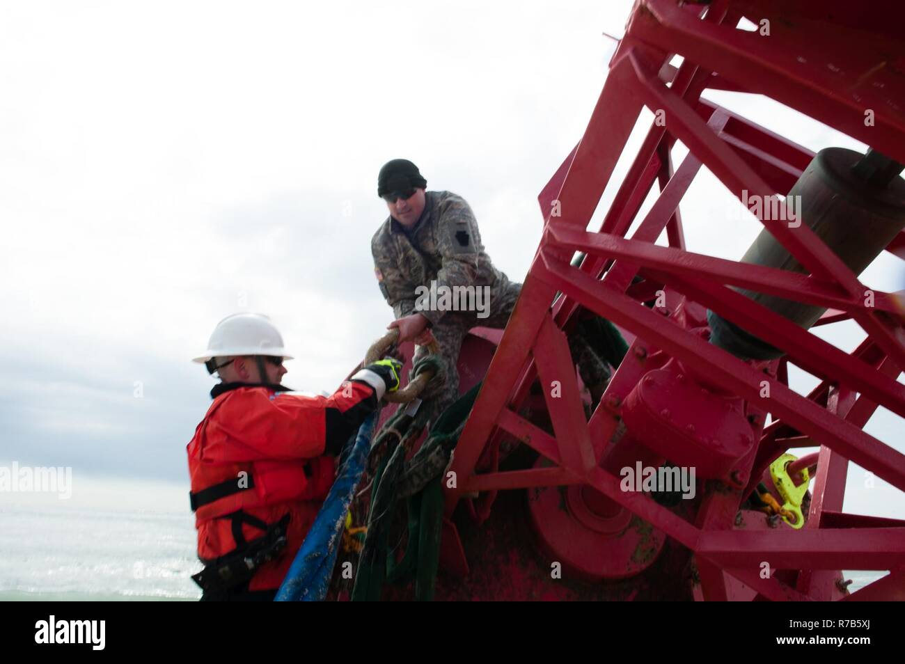 Chief Warrant Officer Benjamin Jewell der Coast Guard Cutter Eiche, und Sgt. 1. Klasse Chris Richards der Connecticut National Guard bereiten Sie eine 12.000-Pound Strände Boje von einem CH-47 Chinook Hubschrauber, Dienstag, 9. Mai 2017, in der Nähe von Chatham, Massachusetts aufgehoben werden. Die Boje war Offshore gebracht, in dem sie durch Coast Guard Cutter Eiche, eine 225-Fuß-Boje, Ausschreibung in Newport, Rhode Island homeported abgeholt wurde. Stockfoto