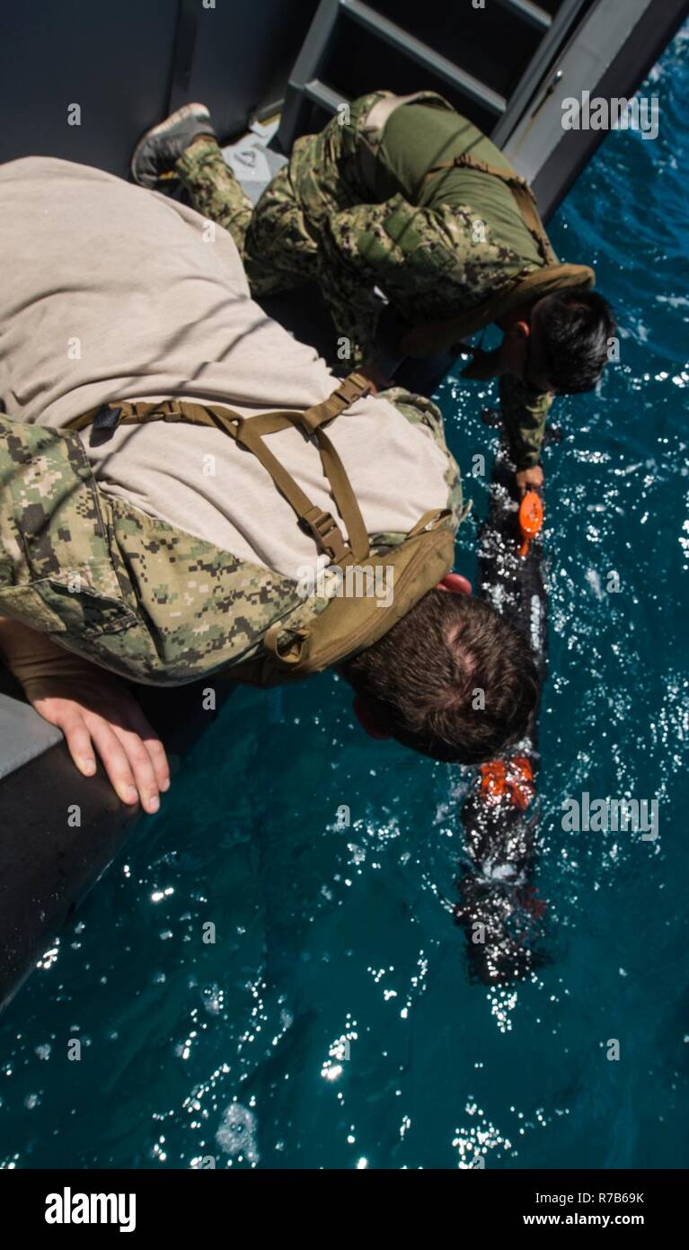 Segler für die Beseitigung von Explosivstoffen Mobile Unit 5 (EODMU 5) Platoon 142 bereitstellen ein unbemanntes Unterwasserfahrzeug von der Küste Riverine Gruppe 1 Loslösung Guam MK VI patrol Boot vor der Küste von Saipan Mai 9, 2017 zugeordnet. EODMU 5 prüft derzeit die Möglichkeit, Vermögenswerte aus verschiedenen Plattformen, einschließlich Hubschrauber- und Patrouillenboote, die adaptive Interoperabilität zu erhöhen. 5 EODMU führt meine Gegenmaßnahmen, Improvised Explosive Device operations, macht sicher explosive Gefahren und entwaffnet Unterwasser sprengstoffe wie Minen. Stockfoto