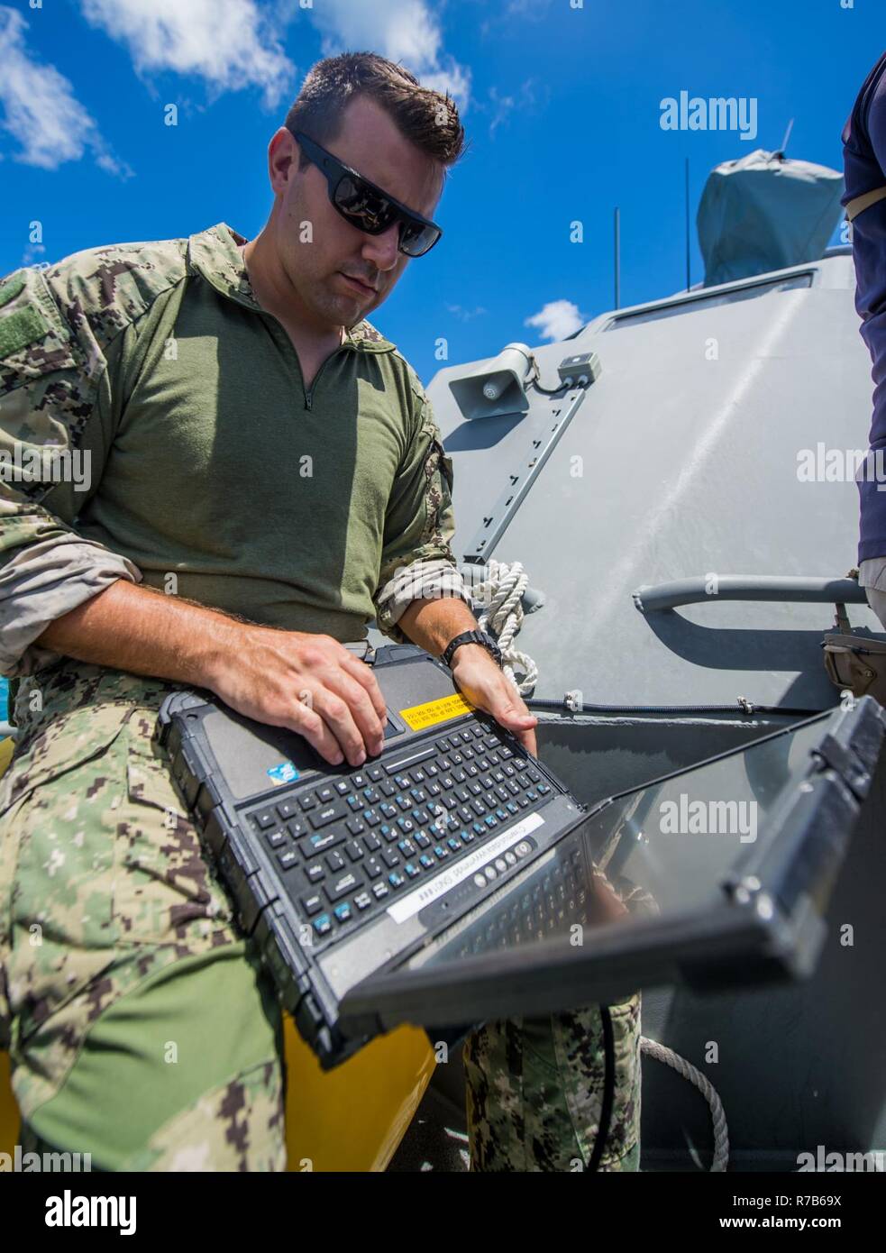 Ein Seemann, der auf die Beseitigung von Explosivstoffen Mobile Unit 5 (EODMU 5) Platoon 142 über ein Laptop an Bord eines Küsten Riverine Gruppe 1 Loslösung Guam MK VI Patrouillenboot Status Updates von ein unbemanntes Unterwasserfahrzeug vor der Küste von Saipan Mai 9, 2017 zu erhalten. EODMU 5 prüft derzeit die Möglichkeit, Vermögenswerte aus verschiedenen Plattformen, einschließlich Hubschrauber- und Patrouillenboote, die adaptive Interoperabilität zu erhöhen. 5 EODMU führt meine Gegenmaßnahmen, Improvised Explosive Device operations, macht sicher explosive Gefahren und entwaffnet Unterwasser sprengstoffe wie Minen. Stockfoto