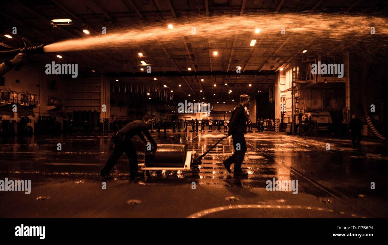 Gewässer östlich von Japan (7. Mai 2017) der Luftfahrt Bootsmann Mate (Handling) Airman Tristan Godeaux, von Alvin, Texas, und der Luftfahrt Bootsmann Mate (Handling) Airman Bruce Kaake, von Amarillo, Texas gießen wasserfilmbildender Schaum auf dem Deck des Hangar Bucht der Marine vorwärts - bereitgestellt Flugzeugträger USS Ronald Reagan (CVN 76), während ein Peeling. Ronald Reagan ist die Durchführung Meer Studien, eine Reihe von Übungen und Auswertungen, die Bereitschaft das Schiff für Ihre kommende Patrol zu überprüfen. Ronald Reagan, das Flaggschiff der Carrier Strike Group 5, bietet eine Bekämpfung bereit, Kraft, schützt und Beklagten Stockfoto