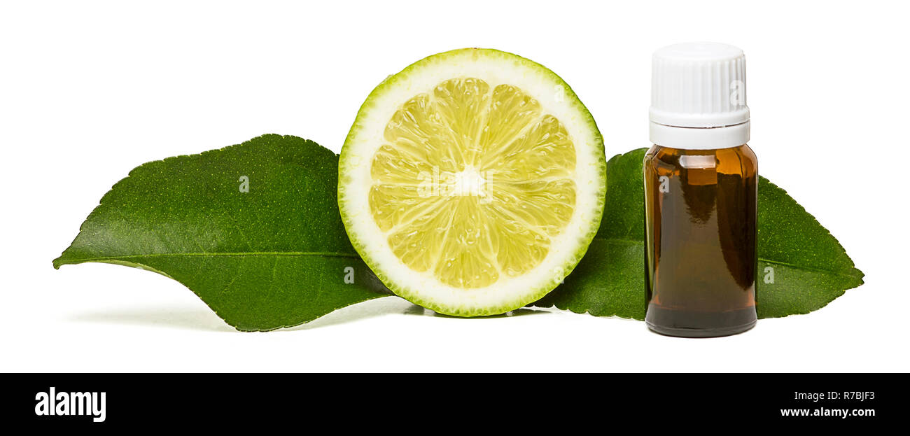 Zitrone ätherisches Öl mit einer halben Zitrone Obst und zwei Blätter auf weißem Hintergrund Stockfoto