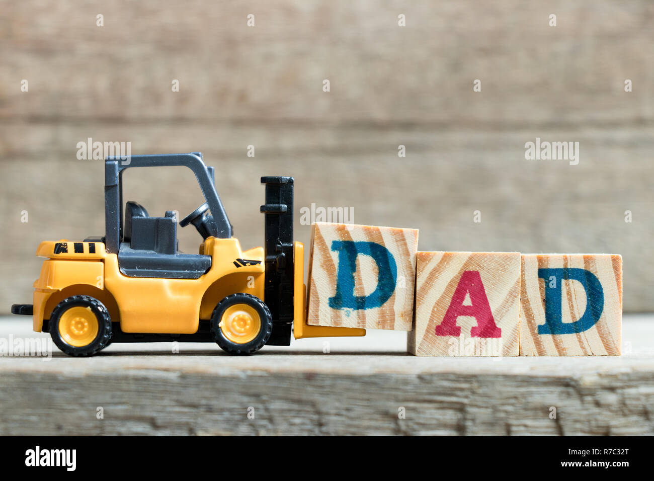 Spielzeug gelb Gabelstapler halten schreiben Block D zu Wort Vati auf Holz Hintergrund komplett (Konzept der Vater Tag) Stockfoto