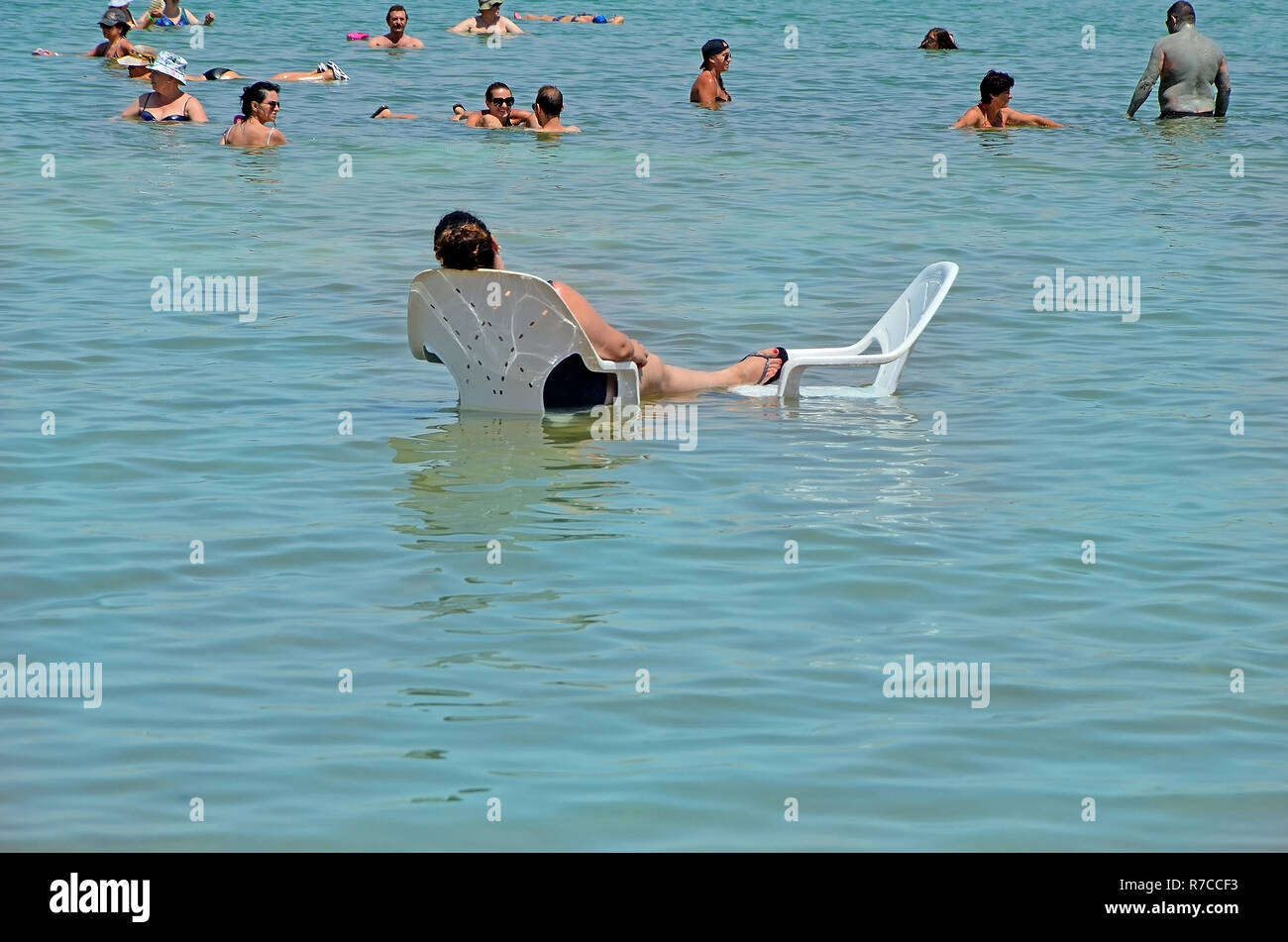 Totes Meer, Israel - 31 Mai 2017: Menschen auf Stühlen entspannt und schwimmt im Wasser des Toten Meeres in Israel. Tourismus, Verbesserung der Gesundheit, Erholung, er Stockfoto