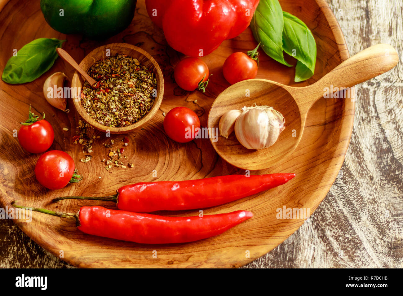 Frische Tomaten, Knoblauch, Nelken, Paprika, Basilikum, rote und grüne Paprikaschoten, Mischung aus trockenen Gewürze und Salz in einem Topf. Stockfoto