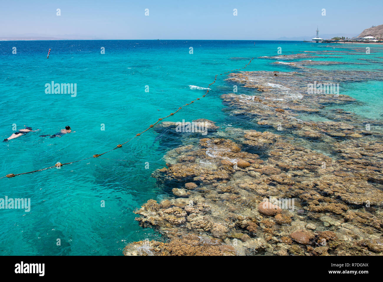 Türkisblauem Wasser und Unterwasser Korallen entlang leeren Strand im beliebten Ferienort Eilat am Roten Meer in Israel. Stockfoto