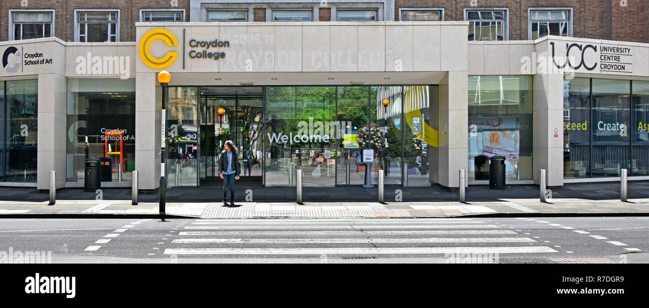 Eine Person neben Belisha Beacon & Fußgängerüberweg außerhalb Eingang & Willkommen bei Croydon College Campus Bildung Gebäude London England Großbritannien Stockfoto