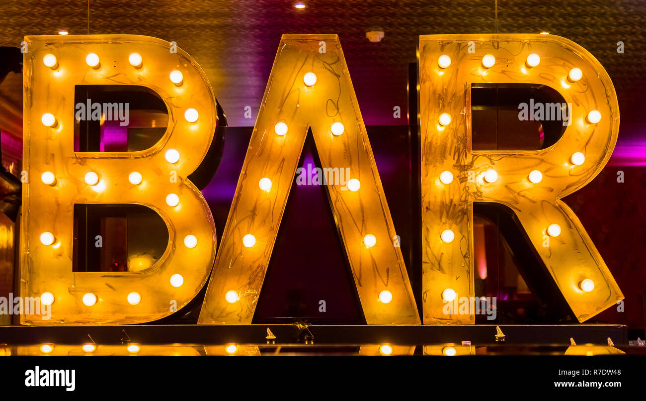 Cocktail Gläser auf einen Tresen mit einem beleuchteten Bar Schild