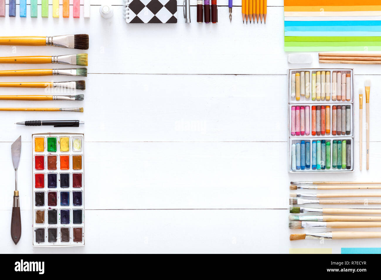 Kreative Werkzeuge Schreibtisch mit Zeichnung Malerei liefert, bunte Farben Pinsel Buntstifte Buntstifte und Schule Zubehör für Kunst auf weißem Holz- ta eingestellt Stockfoto