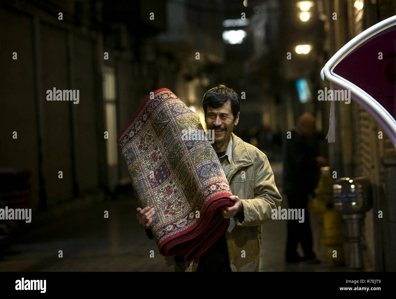 (181209) - Teheran, Dez. 9, 2018 (Xinhua) -- ein Mann trägt einen handgewebten Teppich an einem alten Teppich Basar in der Innenstadt von Teheran, Iran am Dez. 8, 2018. Iran exportiert 176 Millionen US-Dollar im Wert von Hand - Teppiche in den ersten sieben Monaten des aktuellen iranischen Jahr gewebt (21. März-Okt. 22), die eine um 20 Prozent im Vergleich mit dem entsprechenden Zeitraum des letzten Jahres, Eghtesadonline News Website am Dez. 4, 2018 berichtet. (Xinhua / Ahmad Halabisaz) (yy) Stockfoto