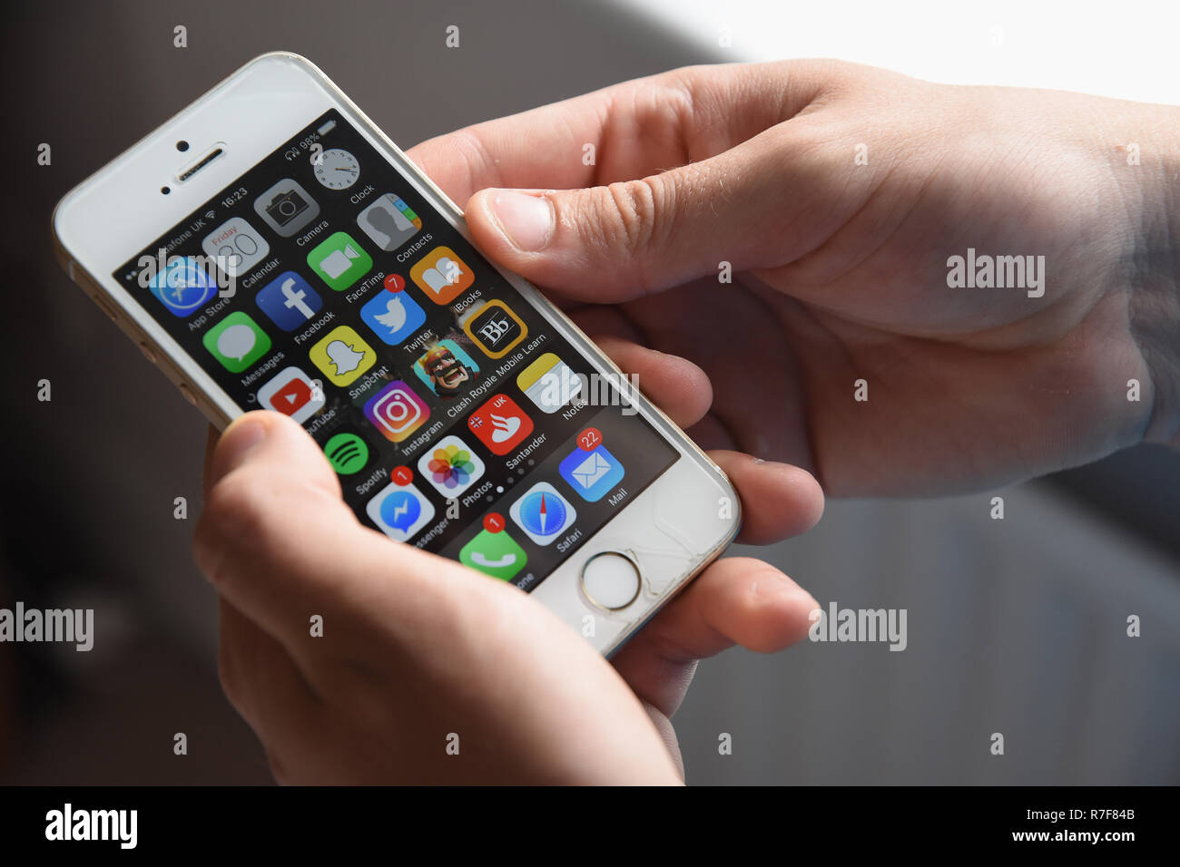 Teenager mit einem Apple iPhone SE Handy anzeigen verschiedene Termine. Stockfoto