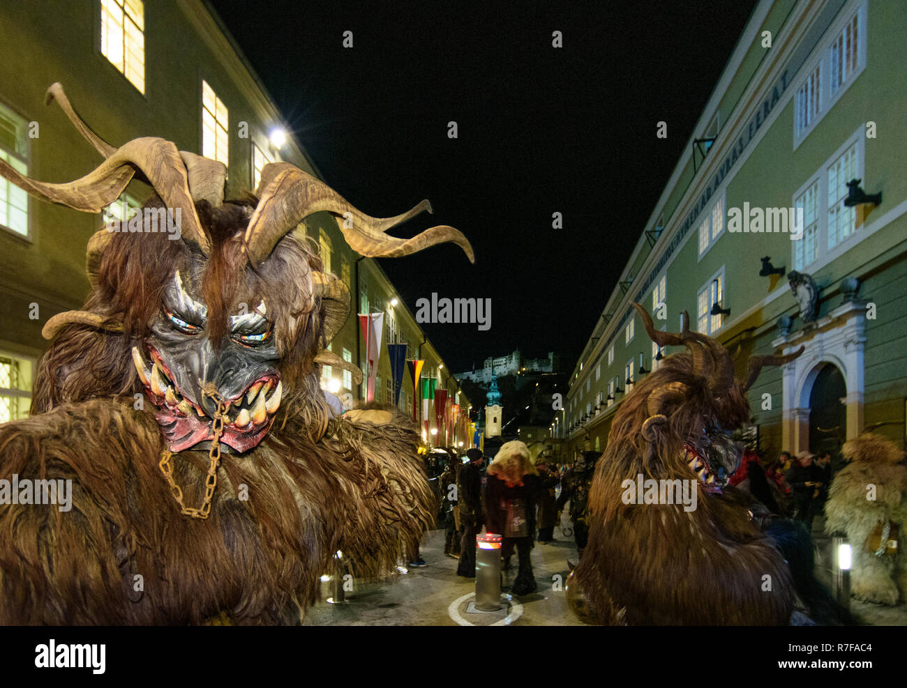 Salzburg: Krampuslauf (Krampus-Lauf, Perchtenlauf, Krampus, Maske Prozession) in der Altstadt in der Straße, in der hofstallgasse zurück Burg Hohensalzburg Stockfoto
