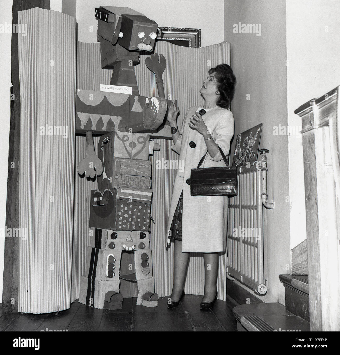 1965, lady Gouverneur an einer Schule stehen, "Die marsworth Mann", ein großer Karton Roboter, dass die Schüler einer Schule klasse gemacht hatte, England, UK. Es war in den frühen 60er Jahren, dass Versuche unternommen wurden, um eine Raumsonde zum Planeten zu fliegen, Mars und 1965 die NASA-Raumsonde Mariner 4 endlich geschafft. Stockfoto