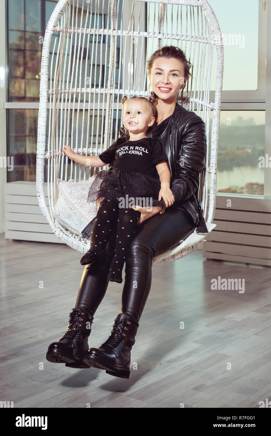 Junge Mutter und Tochter in Leder schwarz passt zu lächeln. Stockfoto