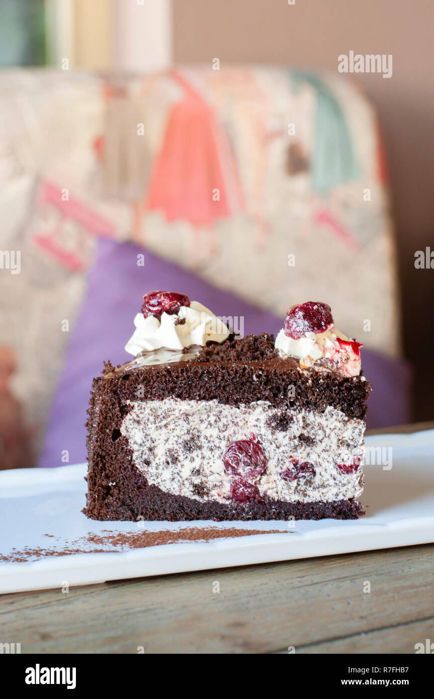 Betrunken Kirschtorte mit Schokolade und Cherry mix auf weiße Platte auf Holz Tisch Stockfoto