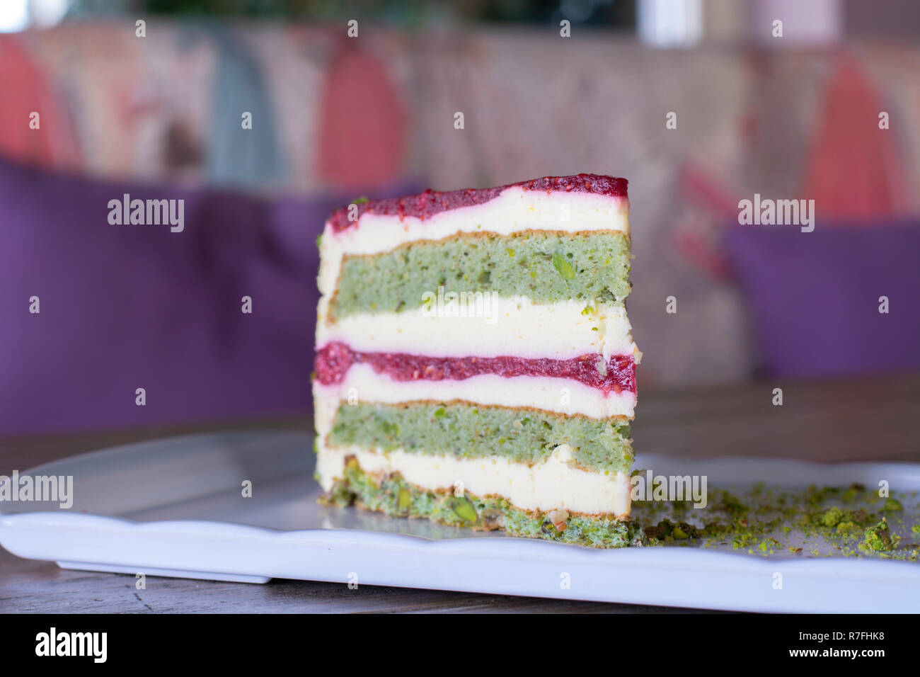 Pistazien und Berry Kuchen auf weiße Platte auf Holz Tisch Stockfoto