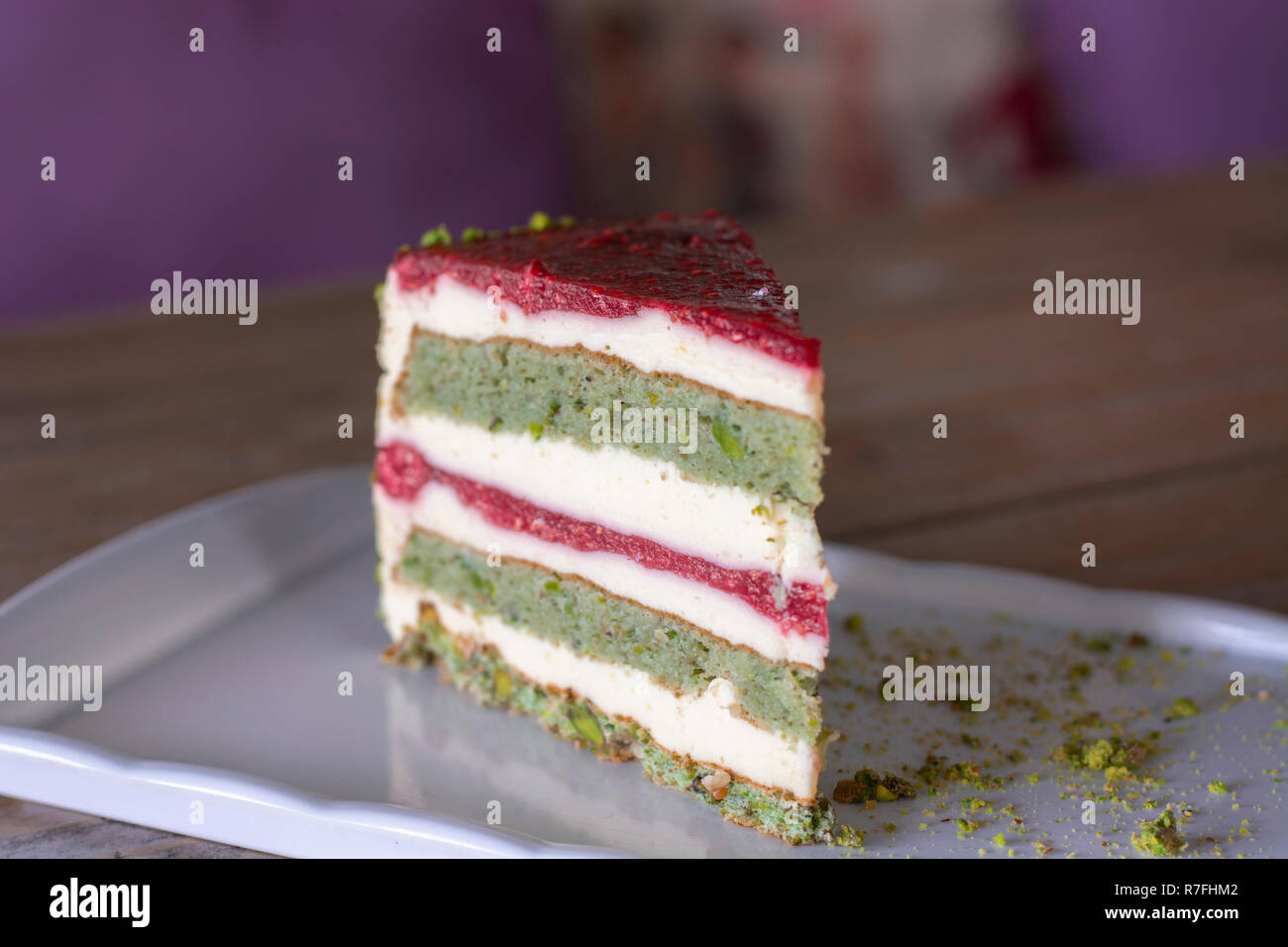 Pistazien und Berry Kuchen auf weiße Platte auf Holz Tisch Stockfoto