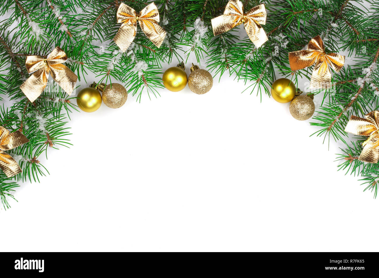 Weihnachten Rahmen der Fir Tree Branch mit goldenen Bögen und Kugeln auf weißem Hintergrund mit Kopie Platz für Ihren Text isoliert. Ansicht von oben. Stockfoto