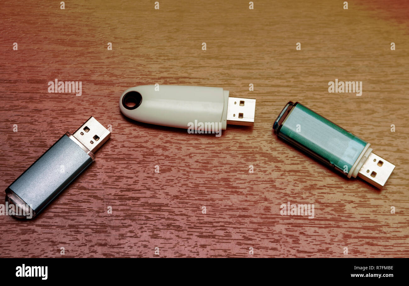 Drei USB Flash Drives sind auf einer hölzernen Oberfläche befindet. Stockfoto