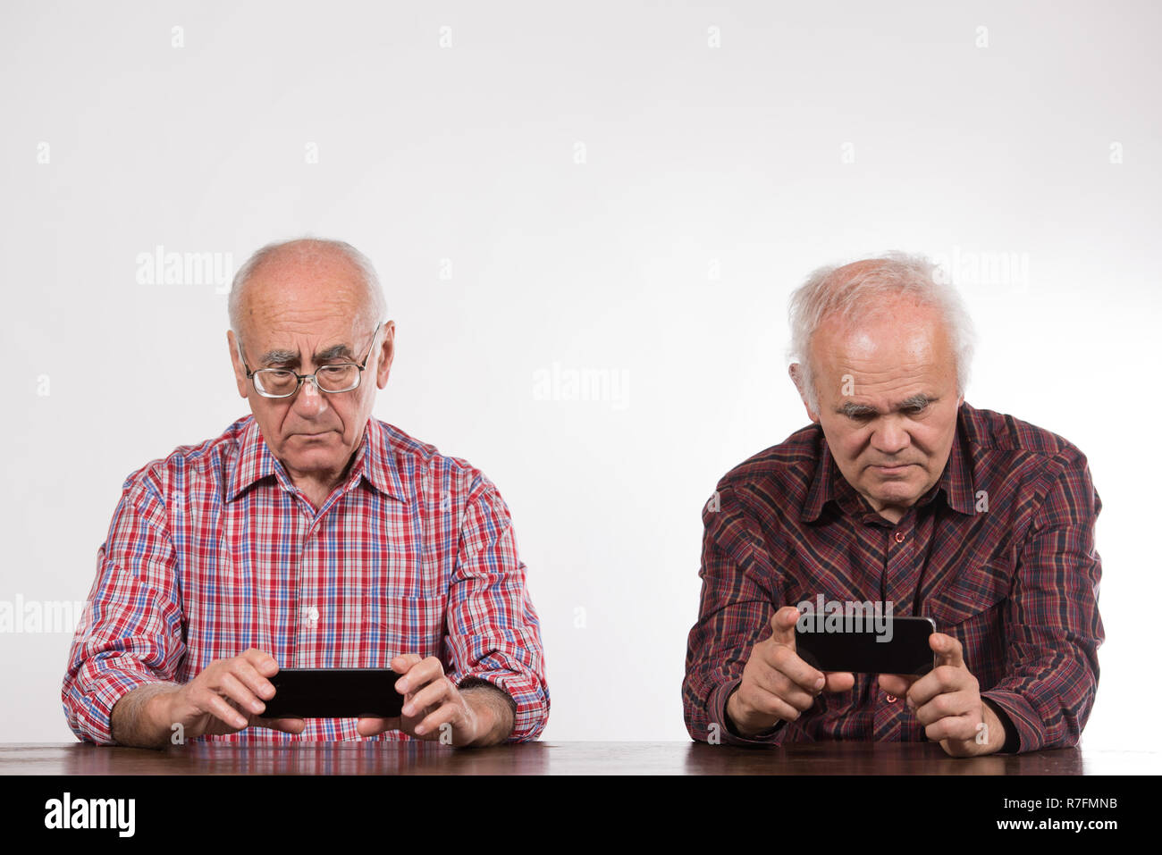 Zwei ältere Männer mit Smart Phones, Spiele Stockfoto
