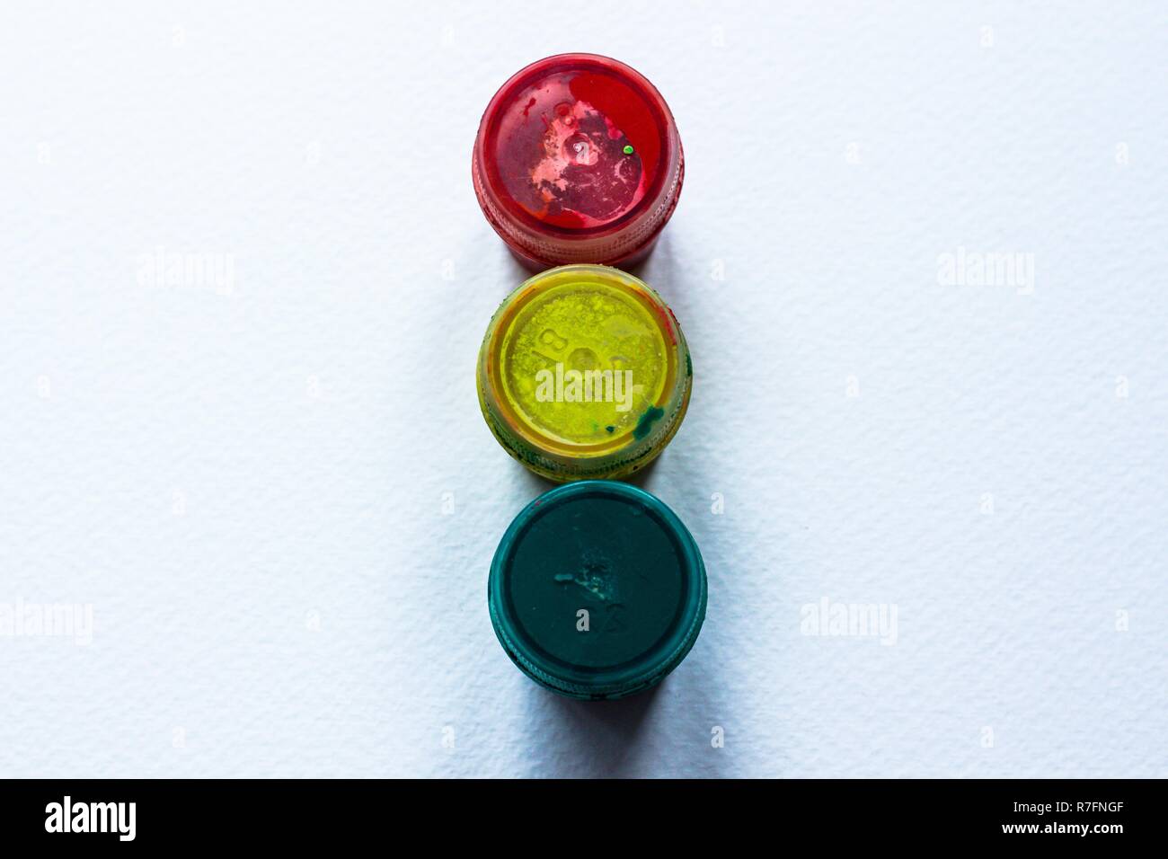 Drei Gläser gelbe, rote und grüne Farbe sind auf weißem Hintergrund in Form einer Ampel. Ein gutes Lernen Abstraktion. Stockfoto