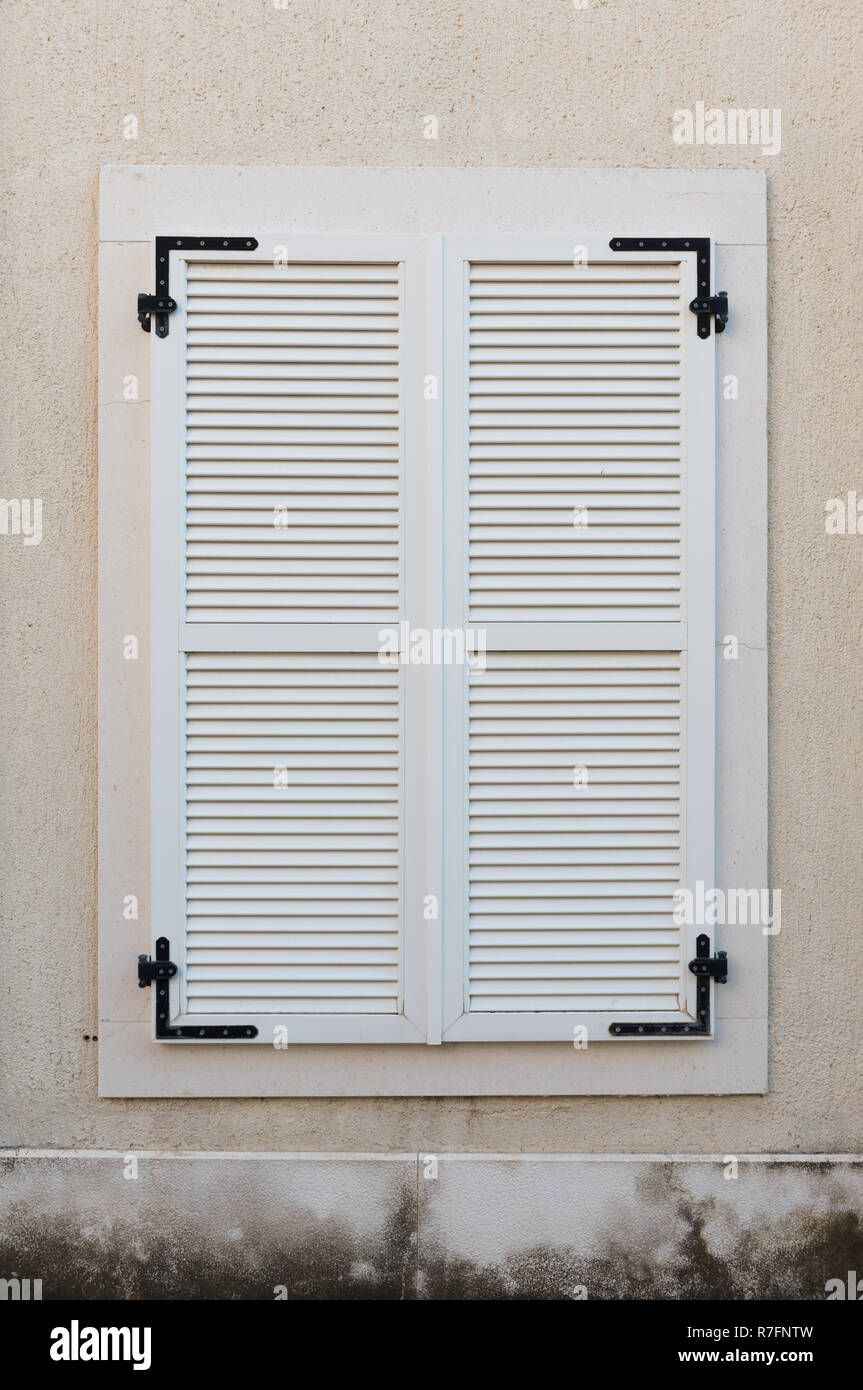 Holz- Fenster mit weißen Fensterläden geschlossen. Äußere Haus details. Stockfoto