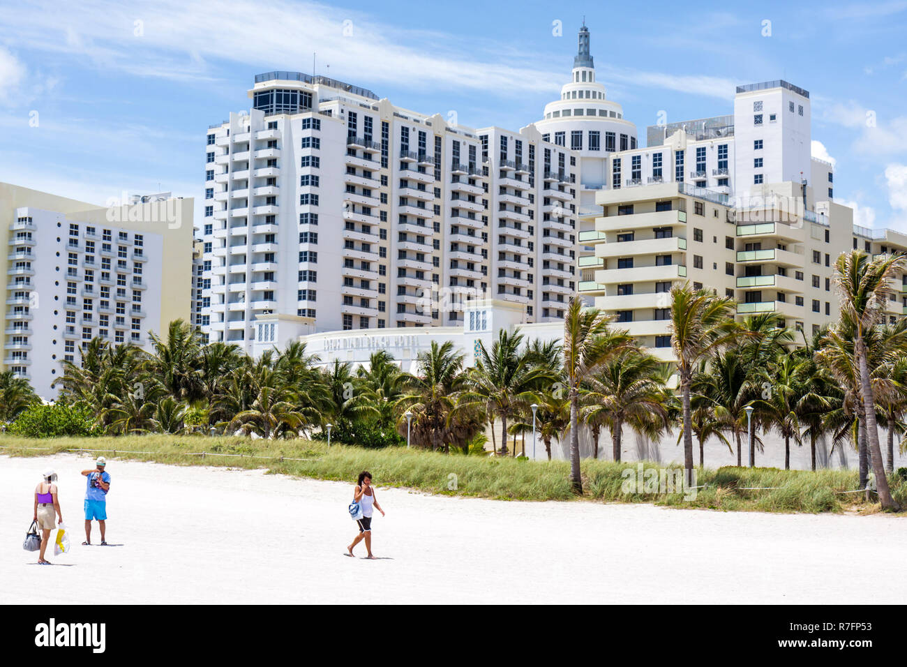 Miami Beach Florida, Loews, Hotel, 1998, Hotel, Hotels, Strand, Gebäude, öffentlicher Strand, hart verpackter Sand, Kokospalmen, künstliche Düne, Gras, Männer m Stockfoto