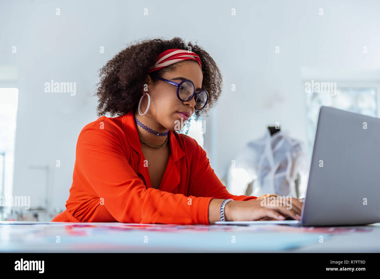 Neugierig ungewöhnliche weibliche Freiberufler Texteingabe auf Ihrem Laptop Stockfoto