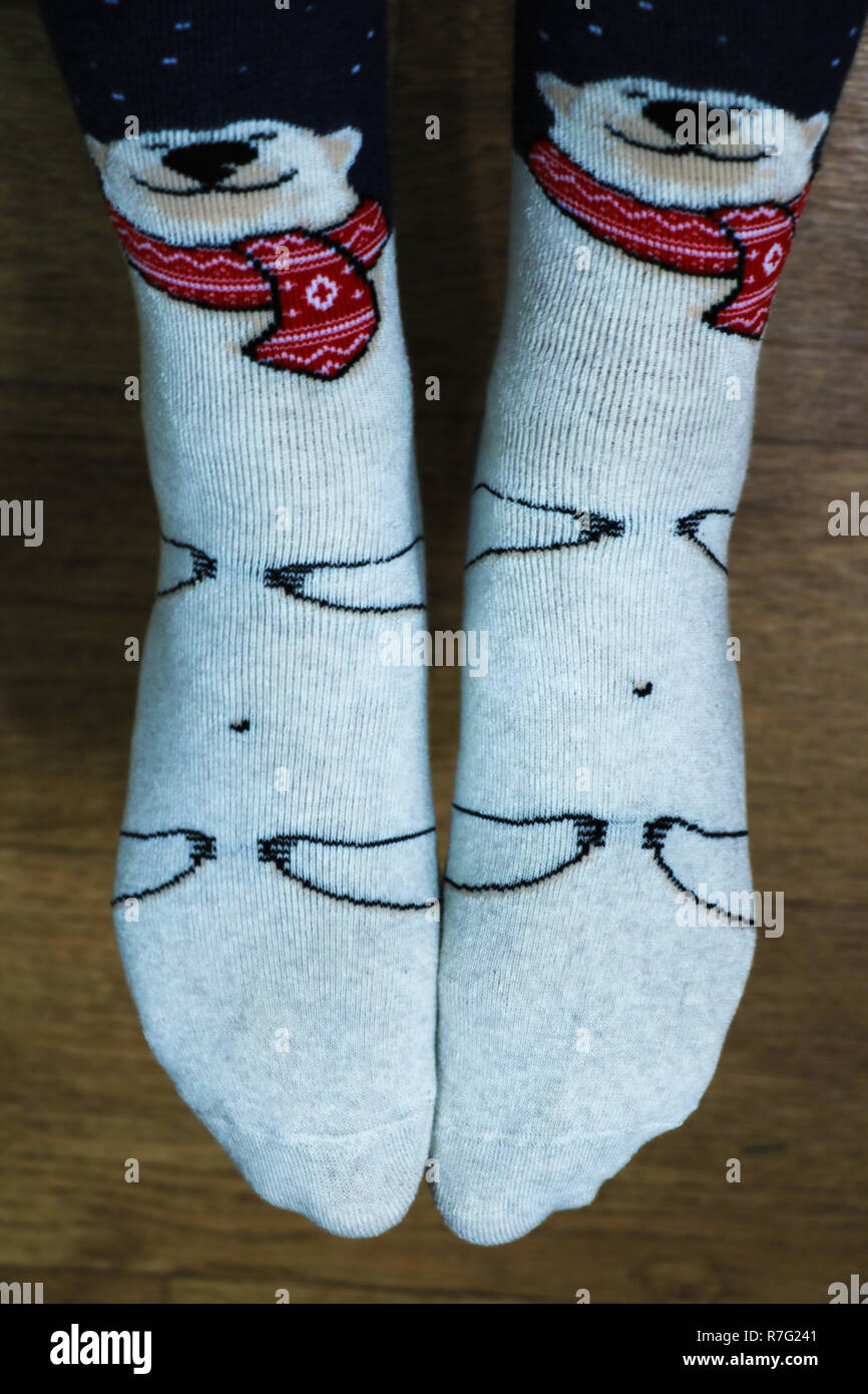 Die Beine der Frauen in warmen schönen Socken auf dem Boden Stockfoto