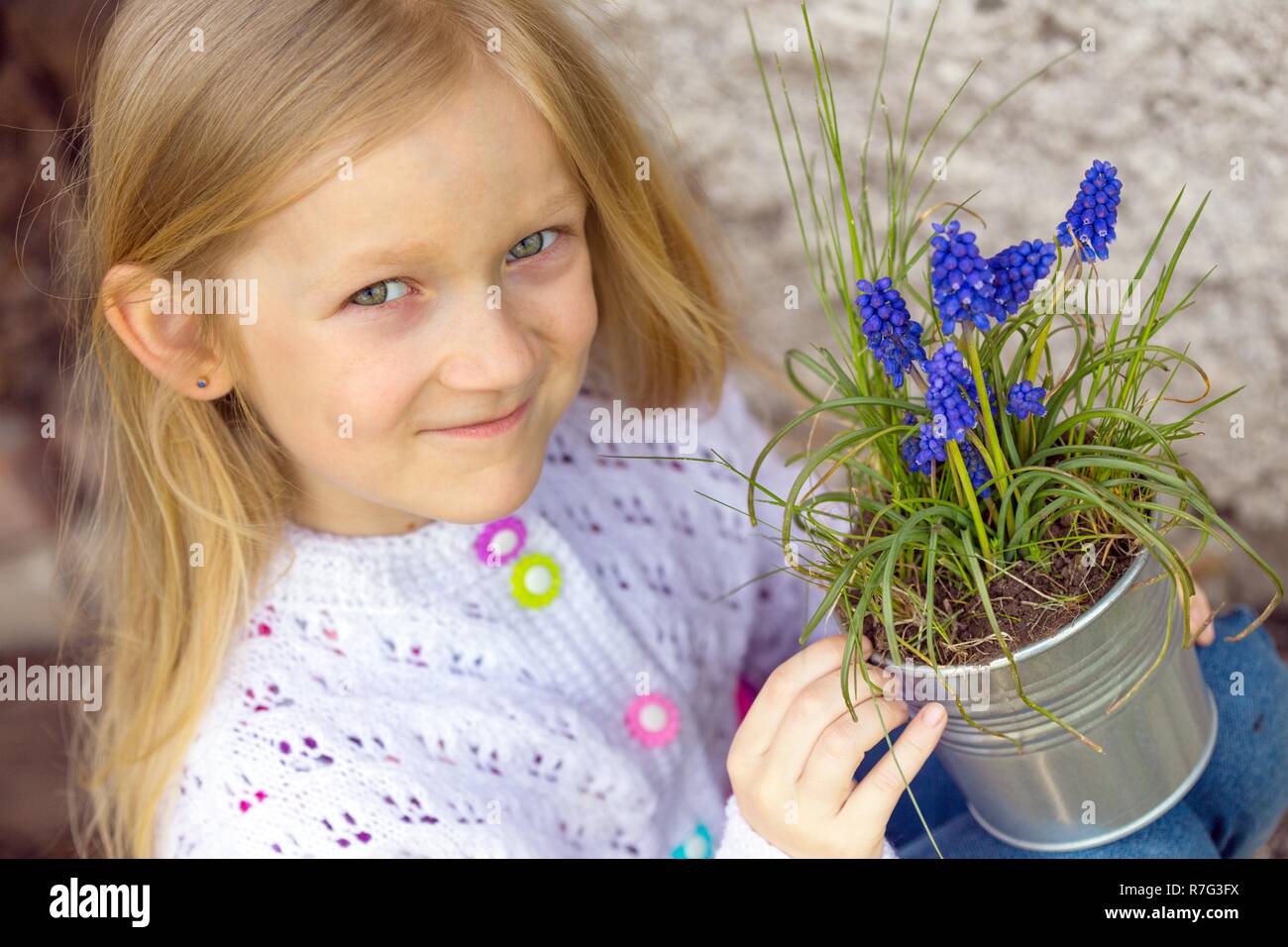 Lächelnde Mädchen mit Blumen Hyazinthen im Topf Stockfoto