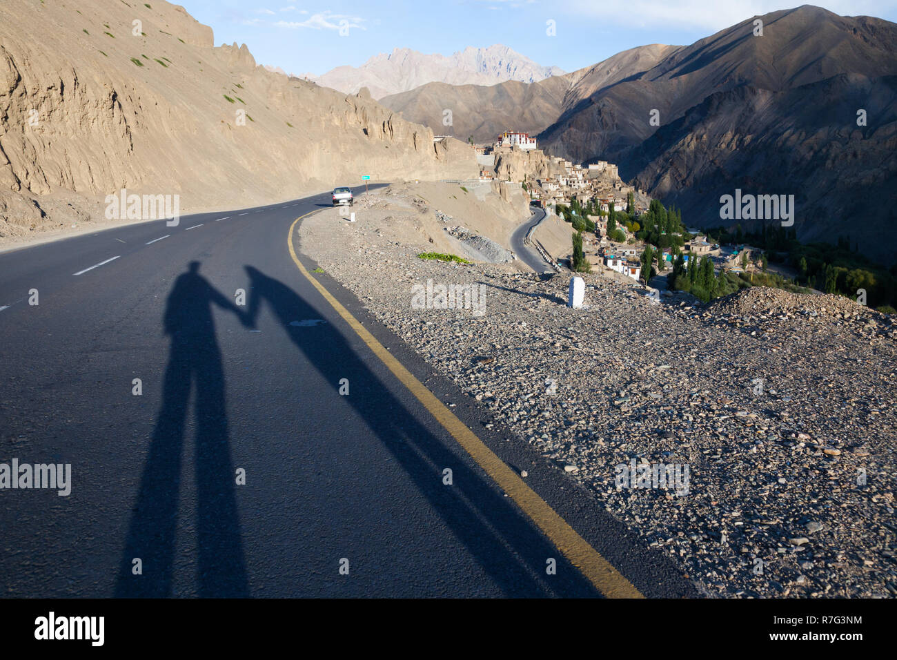 Lange Schatten der Paar Hände halten und stehen auf der Verbindungsstraße von Srinagar und Leh (NH1), in der Nähe von Lamayuru, Ladakh, Jammu und Kaschmir, Indien Stockfoto