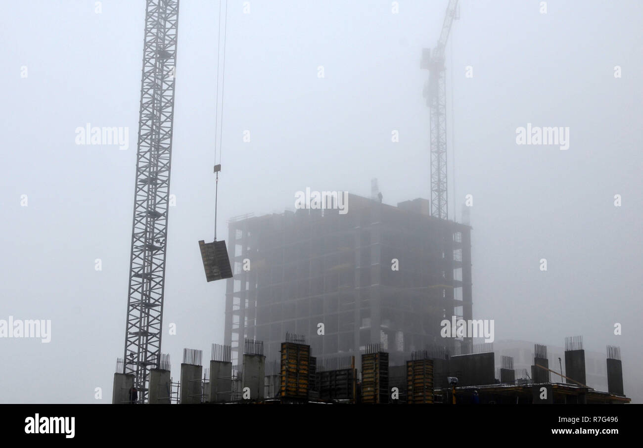 Baukran auf der Baustelle unter den Bedingungen der trübe Wetter und starken mystischen Nebel Stockfoto