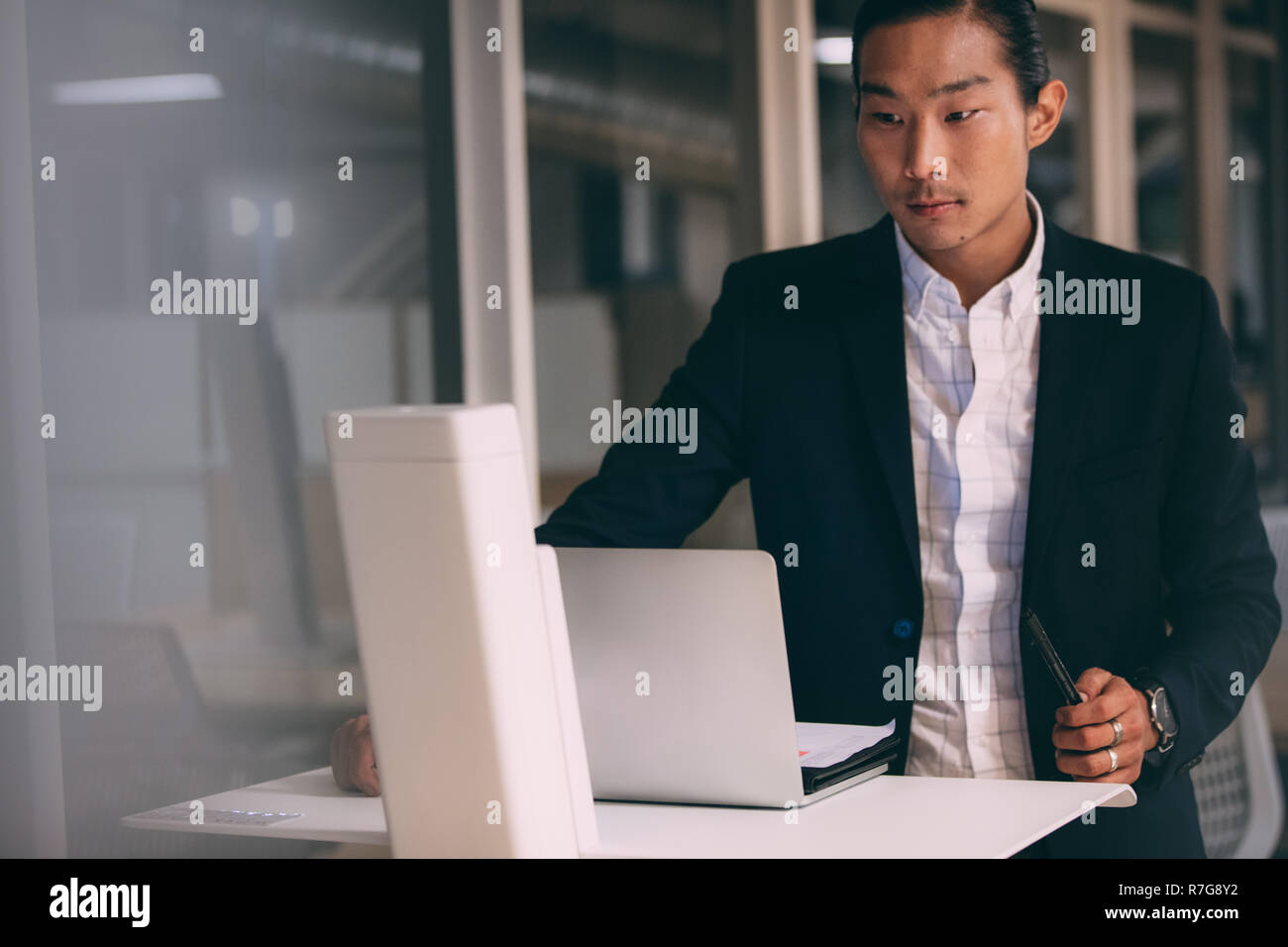 Asiatische Geschäftsmann eine Präsentation steht mit seinem Laptop. Unternehmer im Büro an seinem Laptop. Stockfoto